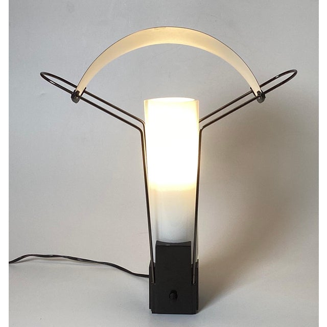 A Pair of Italian Vintage Cooper and white Glass Table Lamps by Arteluce Palio. This design features a copper shade arched...