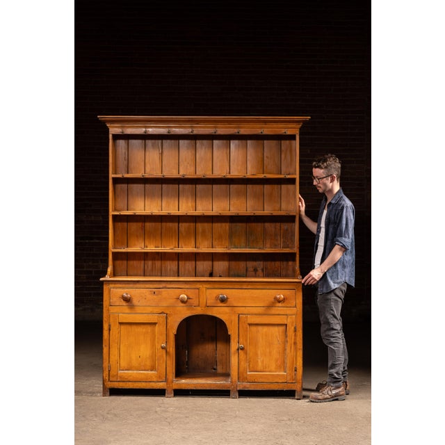 Two-piece pine step-back cupboard featuring a paneled lower cabinet and open upper plate rack. The top section is fitted...