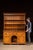 Two-piece pine step-back cupboard featuring a paneled lower cabinet and open upper plate rack. The top section is fitted...
