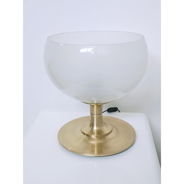 Magnificent lamp in the shape of a giant bowl. Italy, 1970s. The exquisite brass base supports an enormous opaque...