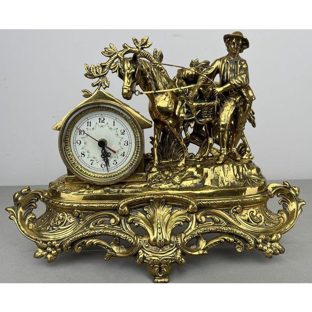 A striking Vintage French clock with an elaborate gold-coloured design, combining a round clock face with a highly...