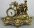 A striking Vintage French clock with an elaborate gold-coloured design, combining a round clock face with a highly...