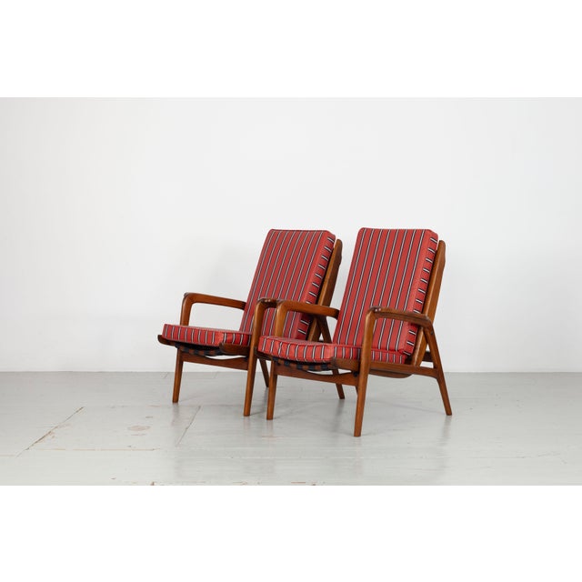 Set of two 1950s armchairs with adjustable backrests Armchairs in stained beechwood with metal and fabric webbing, fitted...