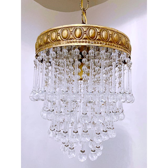 This is an Italian chandelier with decorative brass rim and dressed with fire-polished plain bead chain and handblown...