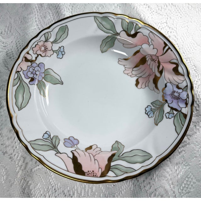 Measuring approximately 10 1/4 inches, this lovely bowl features the distinctive Fleur Fantasia design with colorful peach...