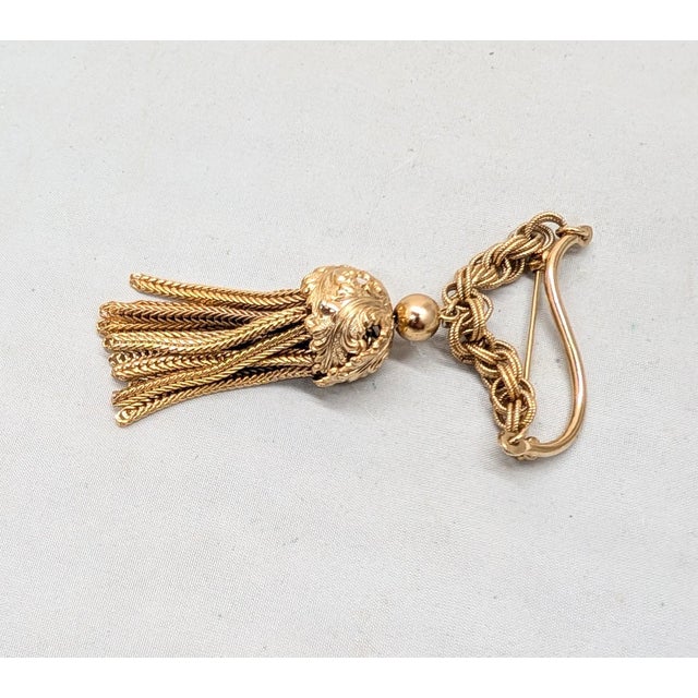 1960s goldtone tassel with "leaves" around the top of the tassel with a wavy bar and chain at the top brooch with security...