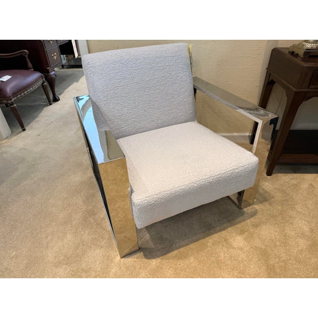 Mid century style cantilever lounge chair with a bold, architectural polished metal frame and crisp modern lines. The seat...