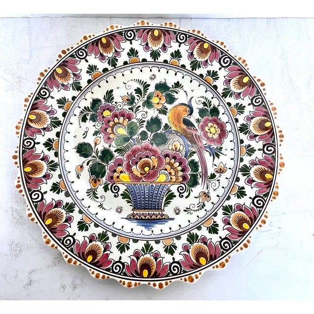 Hand painted in Holland. Vintage Delft Polychrome scalloped edge wall plate. Lovely floral bird of paradise design. The...