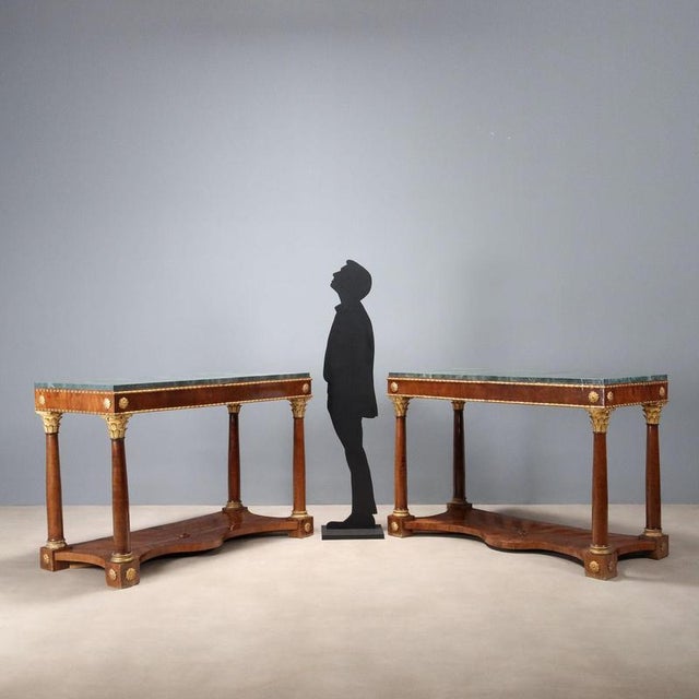 Pair of Empire cherry console tables. Marbled wood top added later, sub-top band with carved rosettes and successive...