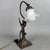 A dramatic and elegant Art Nouveau-inspired table lamp, in which the sculptural plasticity of metal blends with the grace...