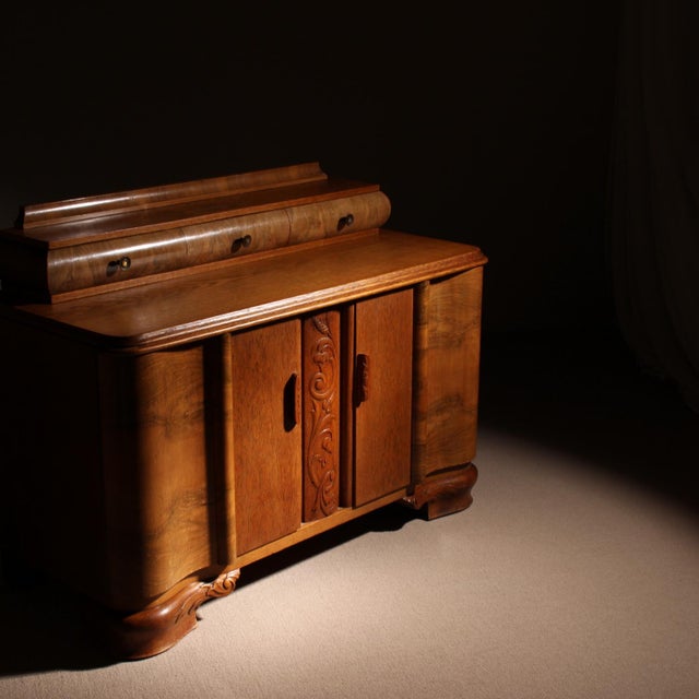 Handcrafted Art Deco sideboard from the 1920s. The piece features a curved silhouette with rounded edges and a front...