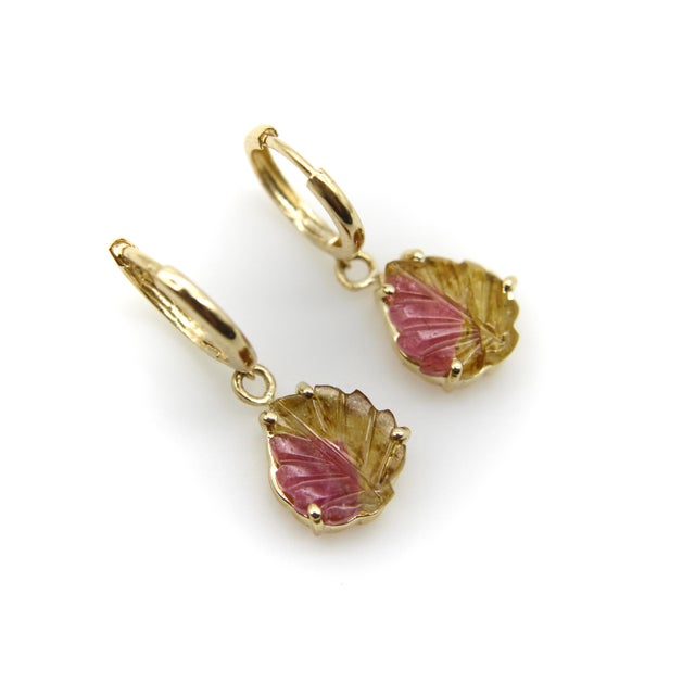 These small 14k gold huggies dangle a beautiful carved leaf watermelon tourmaline. The colors in the stone are a pale pink...