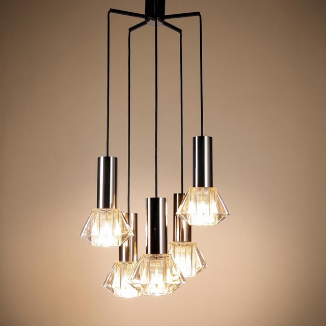 Unique vintage pendant lamp with five pendant lights suspended from a star-shaped ceiling mount on black cables. Each one...