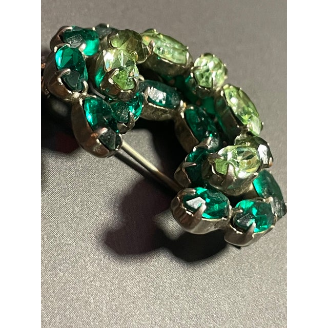 The piece is shaped as a crescent (or horseshoe arc) with an open center. It features a layered, three-dimensional...
