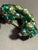 The piece is shaped as a crescent (or horseshoe arc) with an open center. It features a layered, three-dimensional...