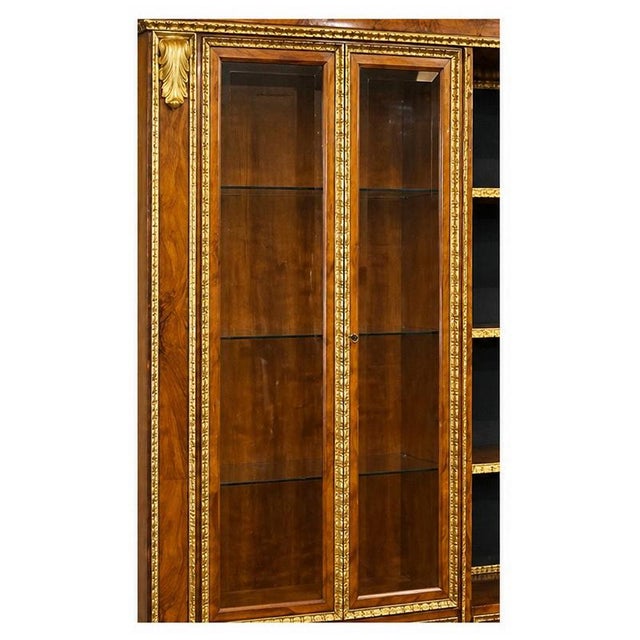 Large walnut and gilded wood bookcase, decorated with rich gilded wood appliqués and carved plant motifs. The front...