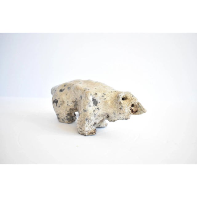 A vintage small animal sculpture of a polar bear, constructed of a formed metal base with a cream craquelure glaze. Date...