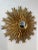 This striking wall mirror features an elaborate sunburst design, with a circular central mirror surrounded by an array of...