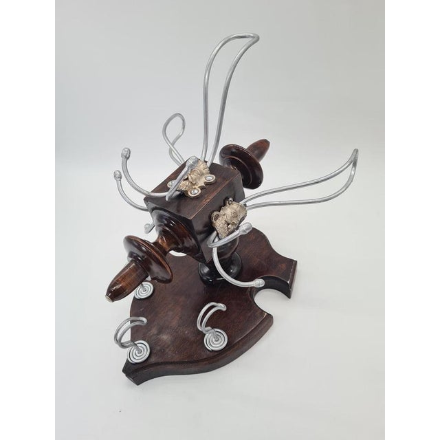 A decorative, highly original wall-mounted coat rack from the early 20th century, crafted from dark-stained wood and...