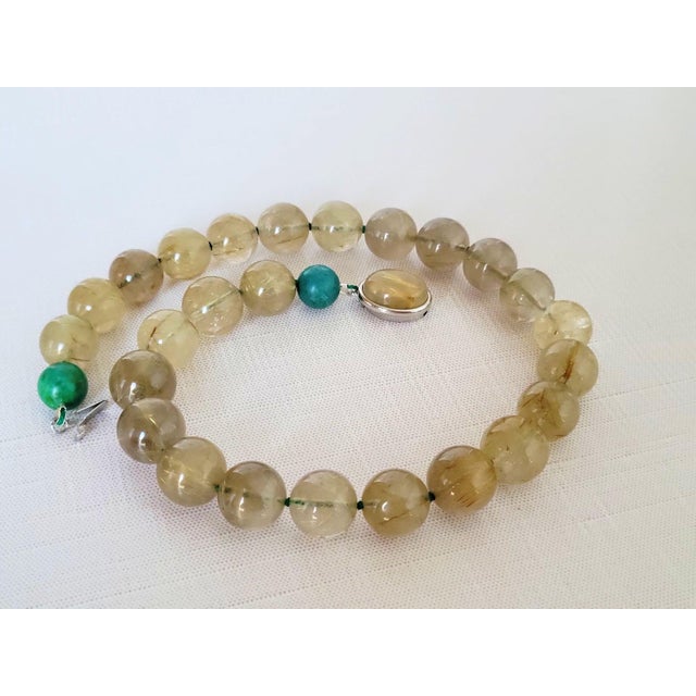 We are delighted to introduce a stunning addition to our collection—a Rutilated Quartz Knotted Necklace accented with two...