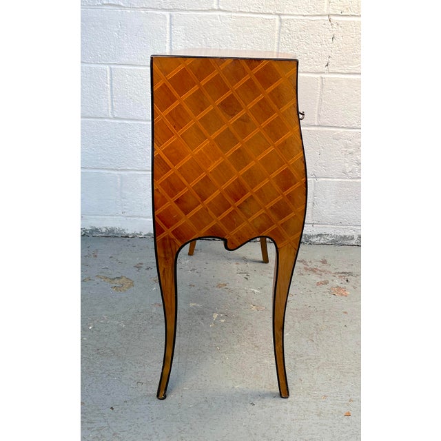 Striking Italian commode, featuring an intricate parquetry design across its facade. The piece combines geometric...