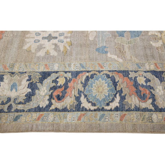 Beautiful modern Sultanabad hand-knotted wool rug with a beige color field. This rug has a navy-blue designed frame with...