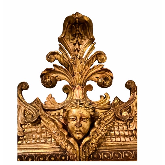 French Antique Gilt Carved Wood Mirror with Cherub Crest, c. 1790 An exceptional and highly decorative French giltwood...