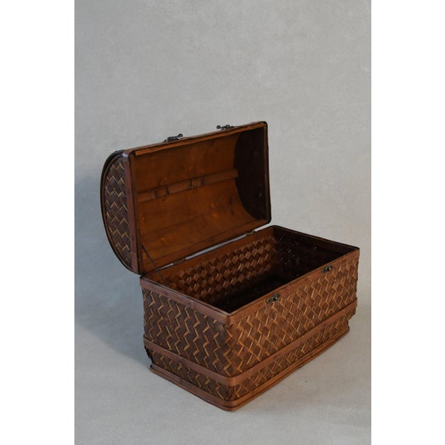 A small woven trunk with a hinged lid, original hardware and a warm, time-worn patina. Use it for storage on a bookshelf...
