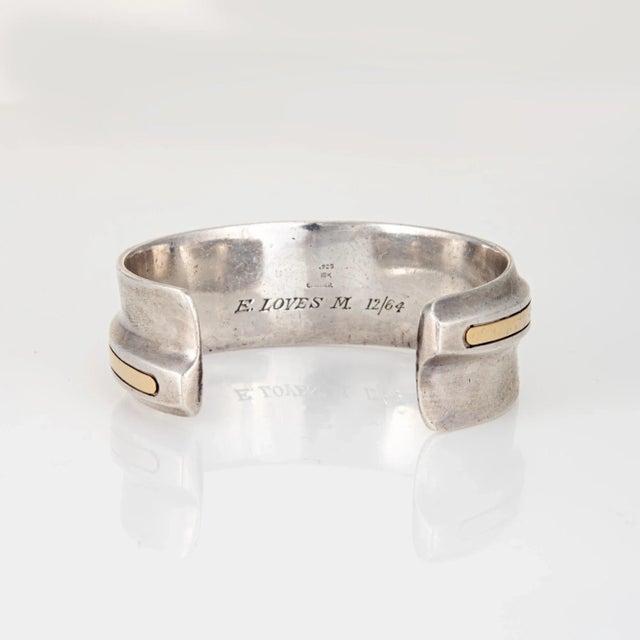 Stylish vintage Cartier cuff bracelet crafted in sterling silver and 18 karat yellow gold (circa 1964). The sculptural...