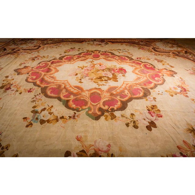This mid-19th-century European Aubusson rug is a 13' x 15' 8" hand-knotted wool piece showcasing refined French...