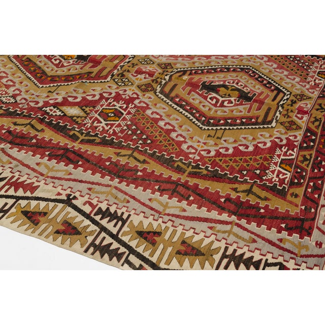 This is a vintage Turkish Oushak rug from the Mid 20th Century. The piece was hand-knotted.