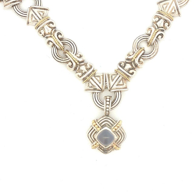 A sterling silver and 18k gold pendant necklace featuring a blue chalcedony cabochon. The necklace measures 18 inches in...