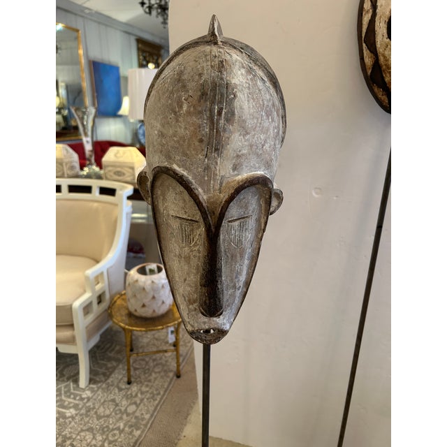 Very impressive trio of hand carved African masks majestically displayed on custom tall iron stands in varying heights....