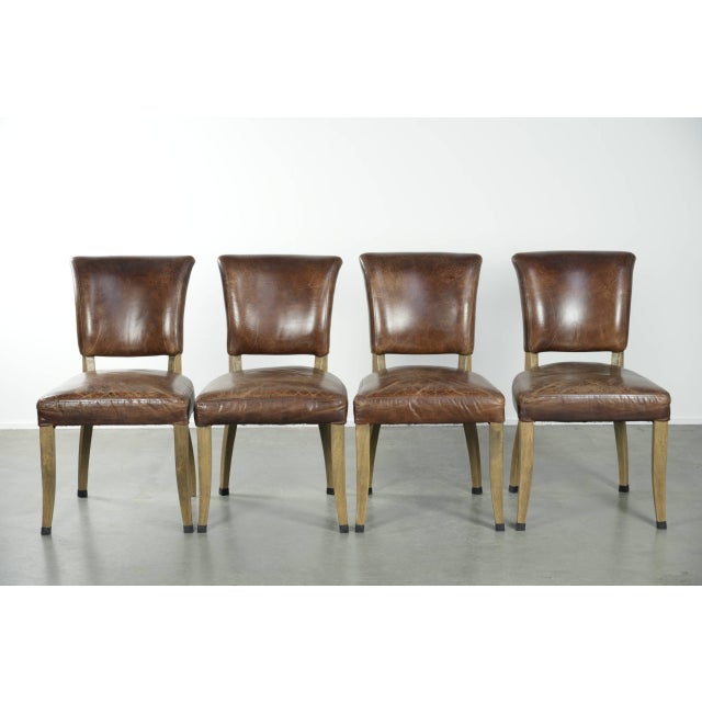 We are offering this set of 4 vintage cowhide leather and wooden dining chairs with a beautiful, characterful, and elegant...