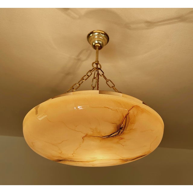 Art Deco pendant light from the 30s with a light salmion pink with watercolor like amber to charcoal veins, the edge of...