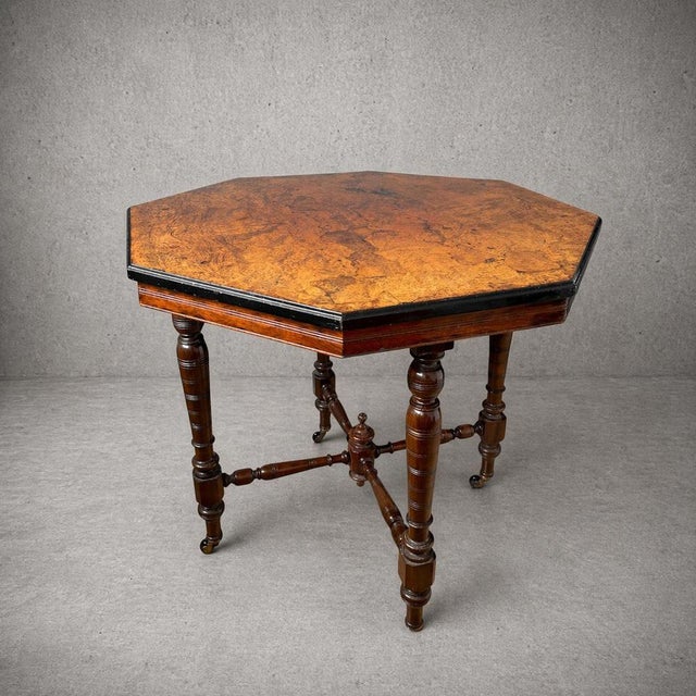 A beautiful antique burr walnut dining table featuring a striking octagonal top with rich, highly figured grain. The...