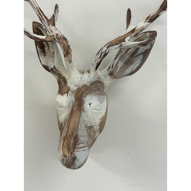 Decorative metal deer head wall sculpture with branching antlers and a distressed white and brown finish. Lightweight...