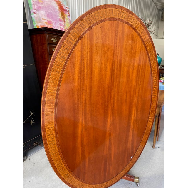 A wonderful and unusually large oval tilt-top table with a satinwood inlaid Greek Key border. This is perfect for an extra...