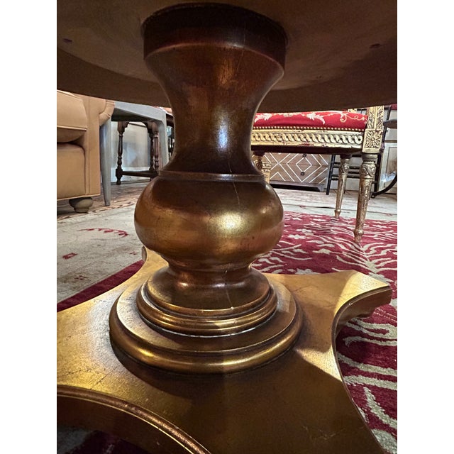 Striking round vintage coffee table have eglomise reverse painting on glass top in a bronze gold color with lovely...