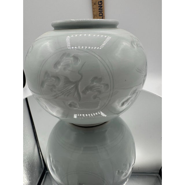 This vintage Korean celadon glazed ceramic vase features a unique crane design, adding a touch of elegance to any space....