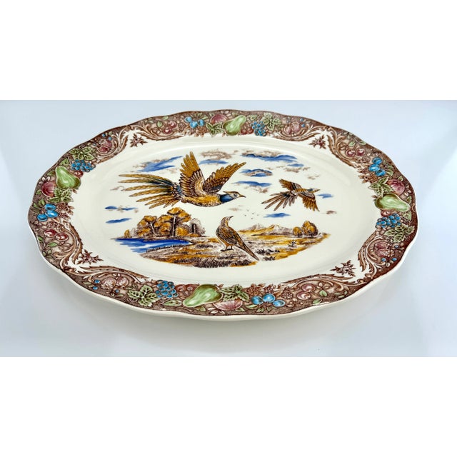 A richly detailed vintage serving platter made in Japan, featuring a vibrant central scene of pheasants in a pastoral...