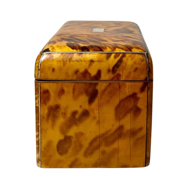A handsome 19th century English faux tortoiseshell tea caddy, beautifully crafted with sterling silver trim and a matching...