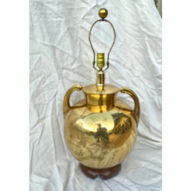 Vintage Brass Chinoiserie Etched Koi Fish Design Urn Table Lamp with a wood base. Large handles with a brass finial....
