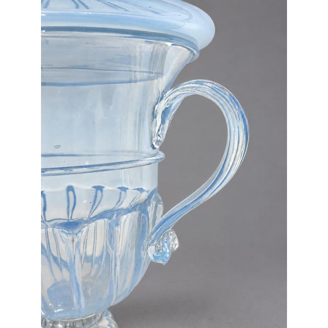 An elegant covered urn in hand-blown opalescent glass, probably Murano, Italy. The classically inspired form combines a...