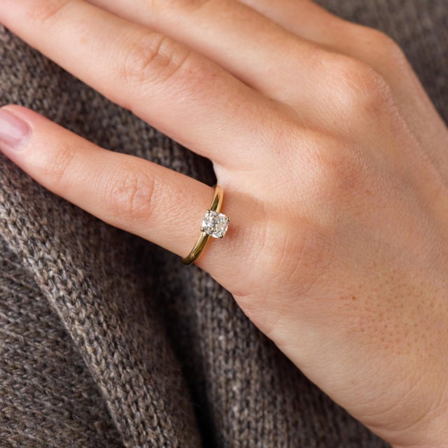 This elegant vintage solitaire engagement ring is centered by a GIA-certified old mine cut diamond weighing 0.91 carat....