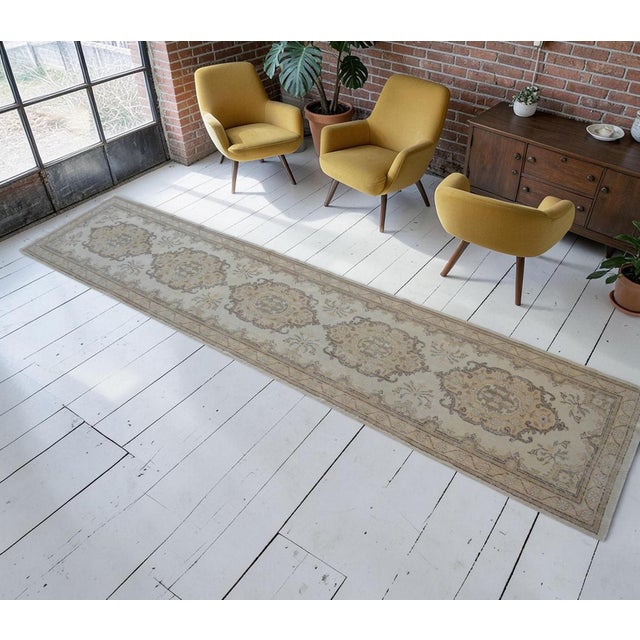 Vintage 1960s distressed Turkish Oushak rug runner. With beige field and shades of brown, ivory and tan throughout....