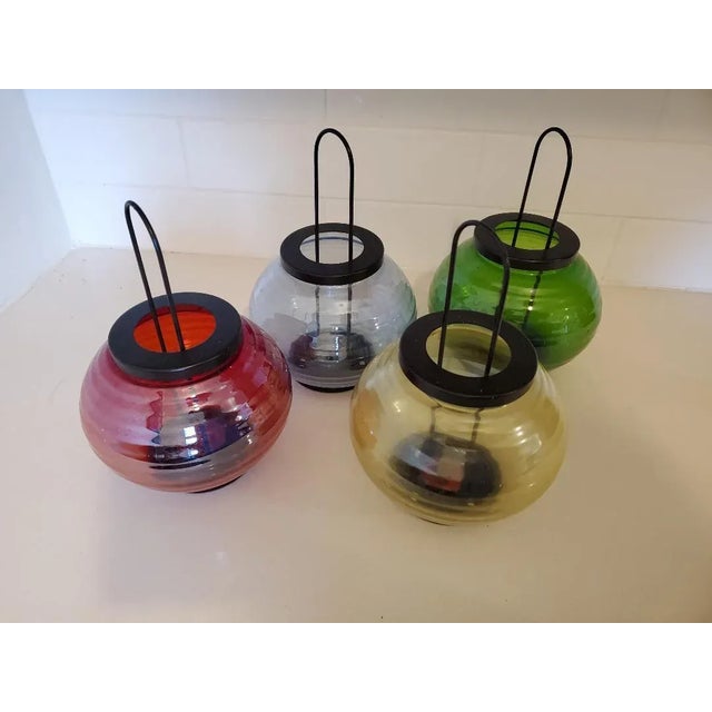 Fabulous set of four fun vintage colored glass lanterns with black metal handles in very good condition consistent with...