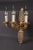 Decorative wall light in Empire style. Finely engraved and cast bronze. Three stylized, full horn-formed, sweeping light...