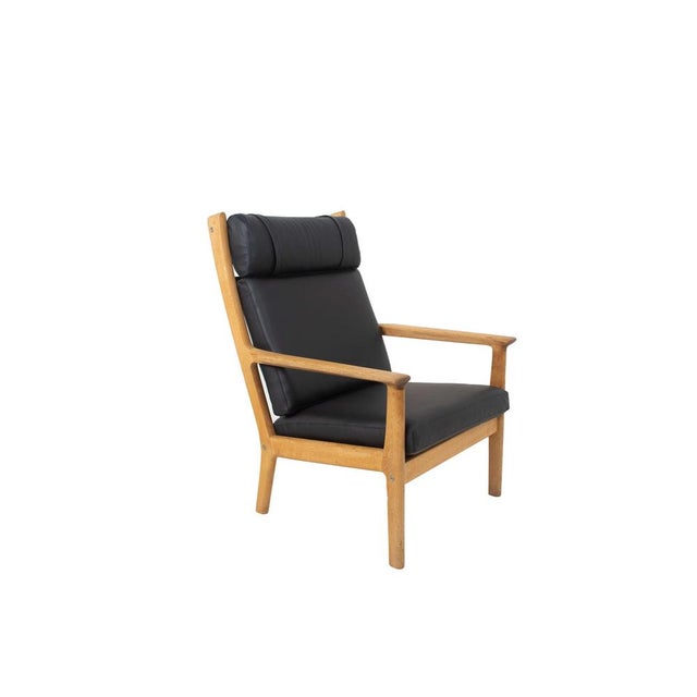 Robust Hans Wegner Fauteuil GE 265 For Getama in Oak and Black Leather, 1980. This chair has new upholstery in black...