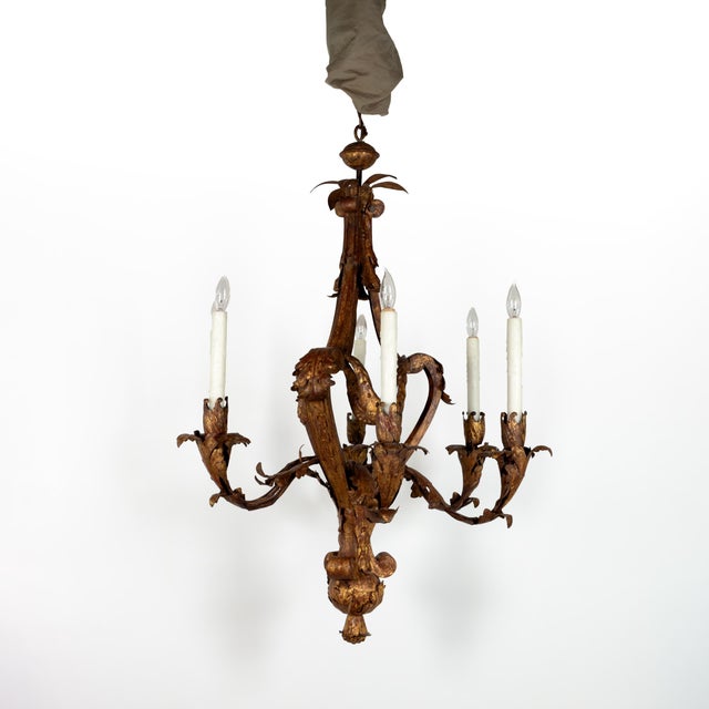 A late 19th-century French gilt tole six-light chandelier with scrolling acanthus, each arm ending in a stylized foliate...